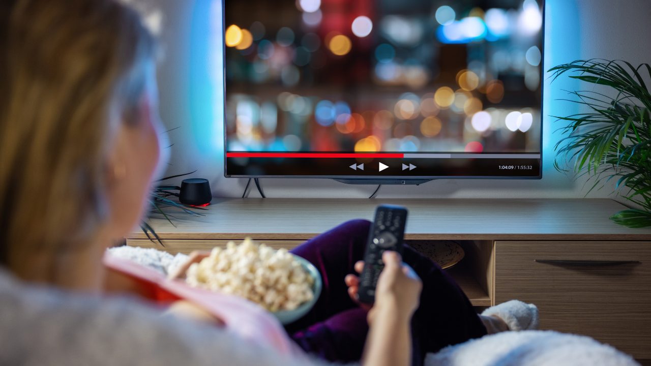 Persona che guarda una serie in streaming comodamente sul divano